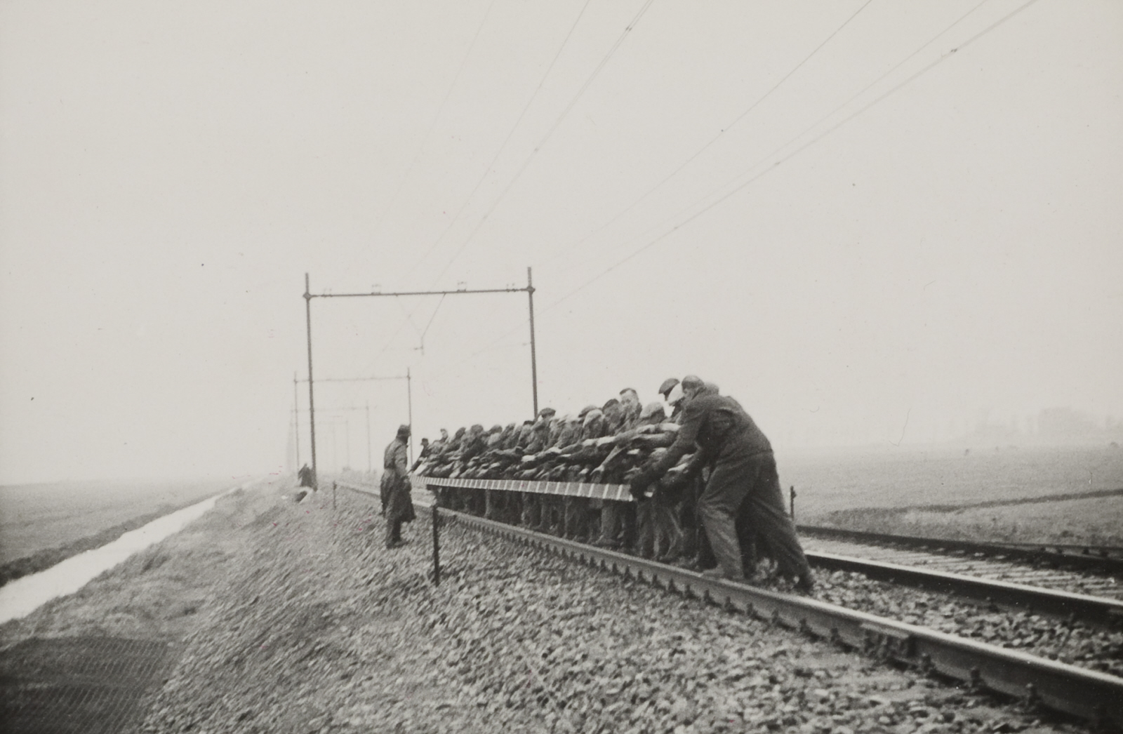 Werkmannen gooien een spoorstaaf weg op het baanvak Utrecht - Arnhem