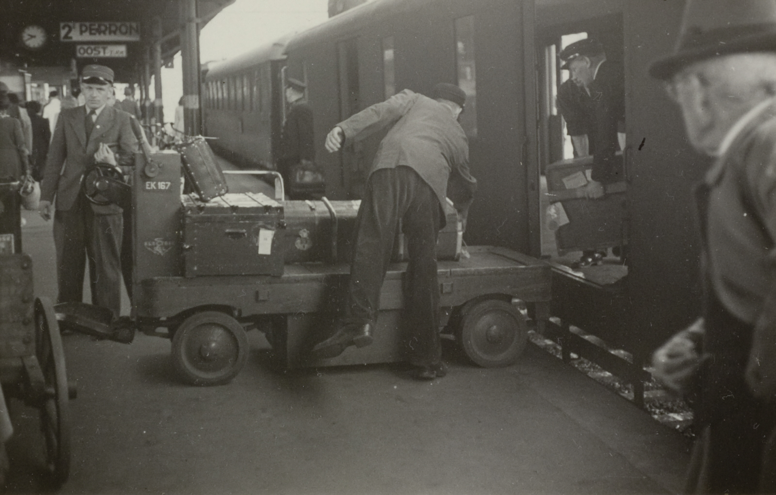 Stationsassistenten met een bagagewagentje op het station van Arnhem