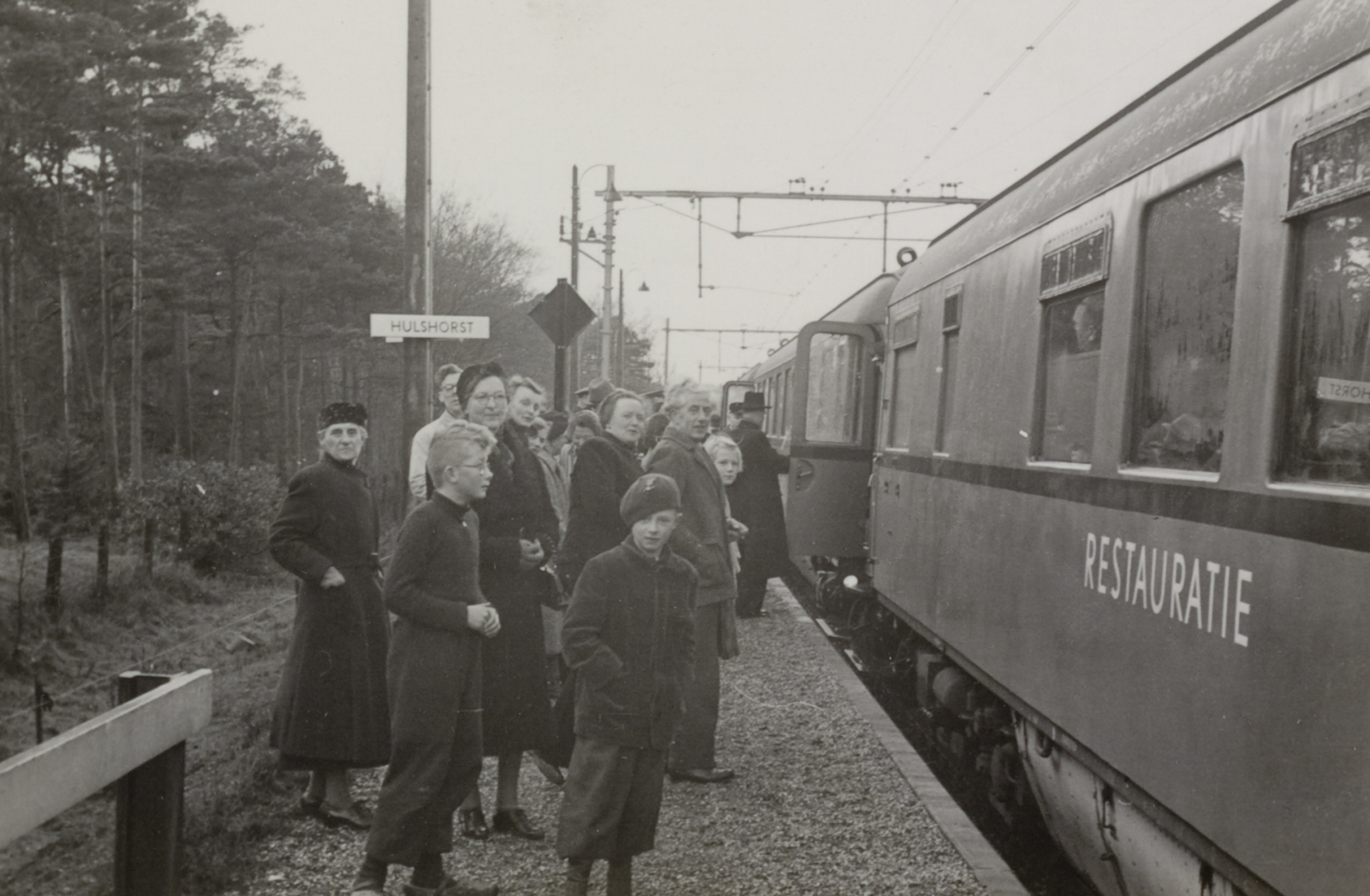 Een groep genodigden stappen uit een restauratiewagen op het station Hulshorst