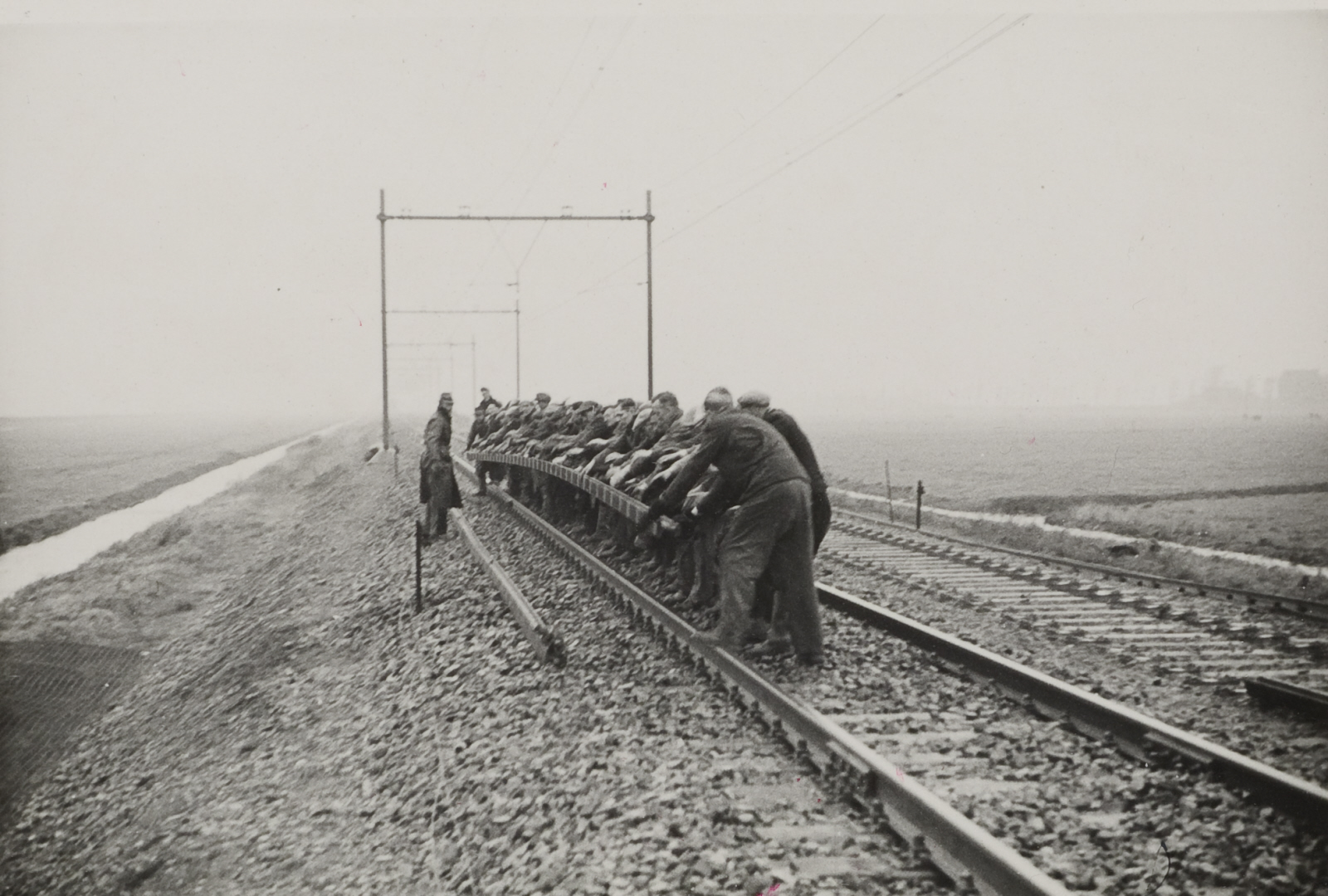 Mannen gooien een spoorstaaf weg op het baanvak Utrecht - Arnhem