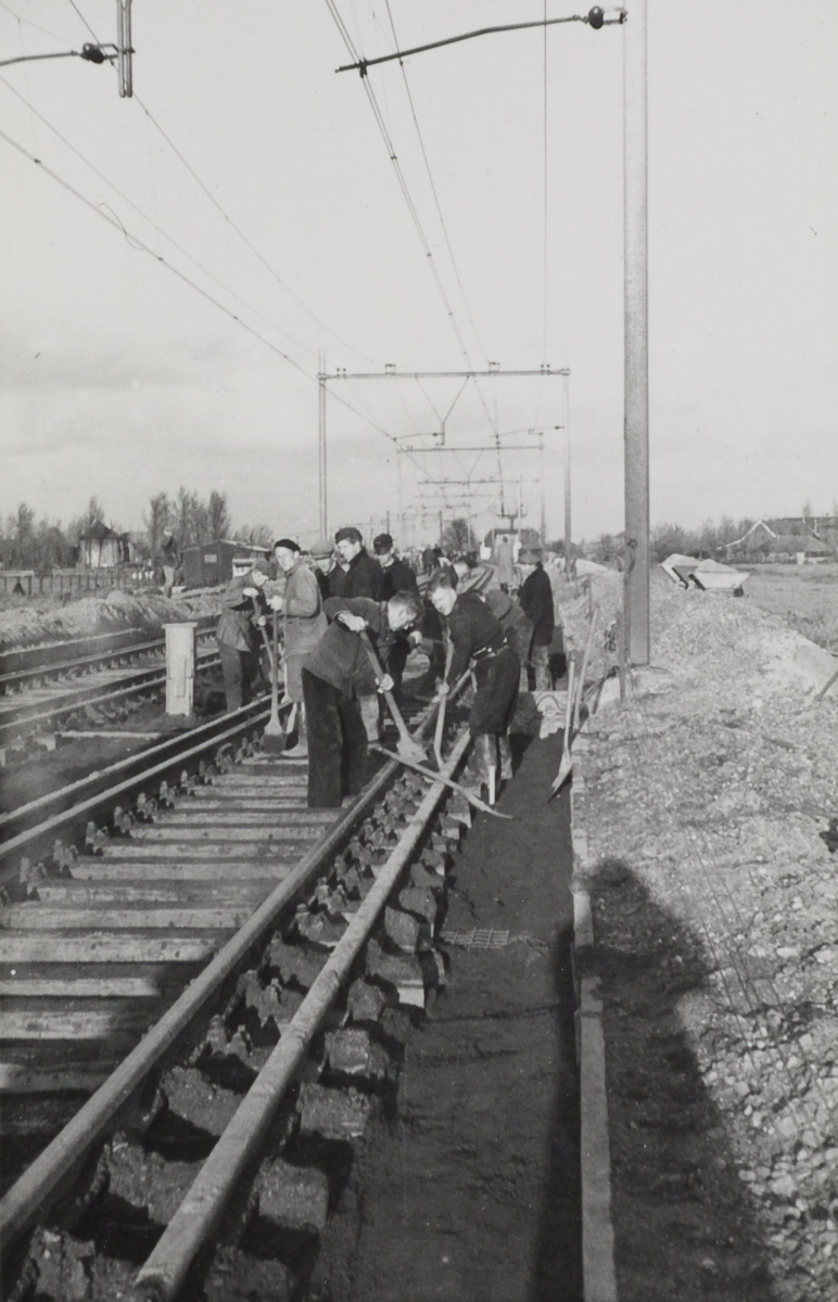 Werkmannen met lepels en scheppen op het spoor bij Duivendrecht