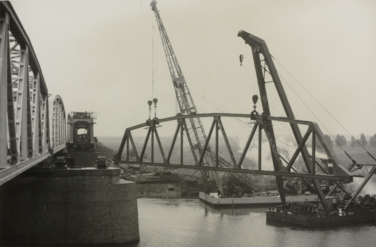 Een brugzijkant wordt op een nieuwe brug gehesen bij Buggenum