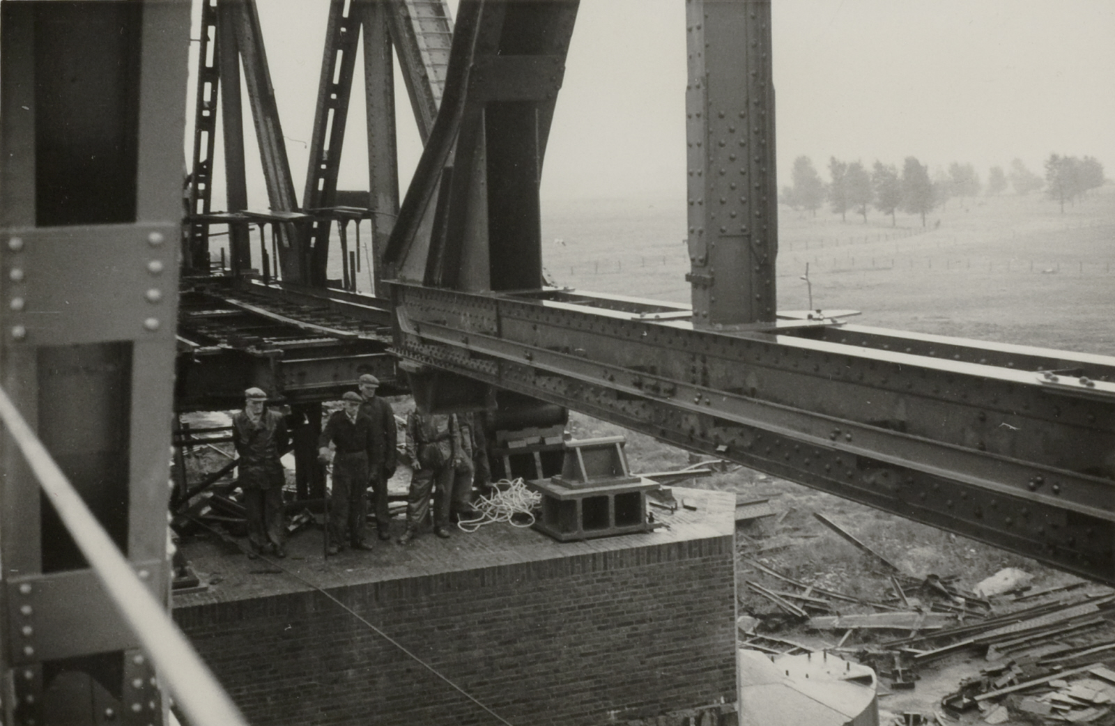 Werkmannen manoeuvreren een brugdeel op een pijler bij Buggenum