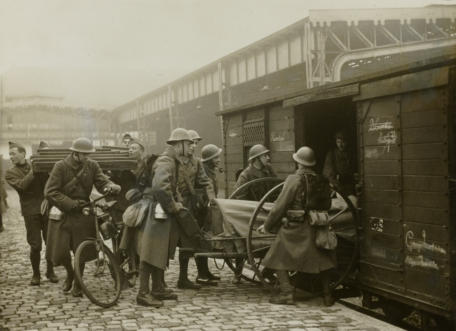 Soldaten laden een goederenwagen op het station Scheveningen
