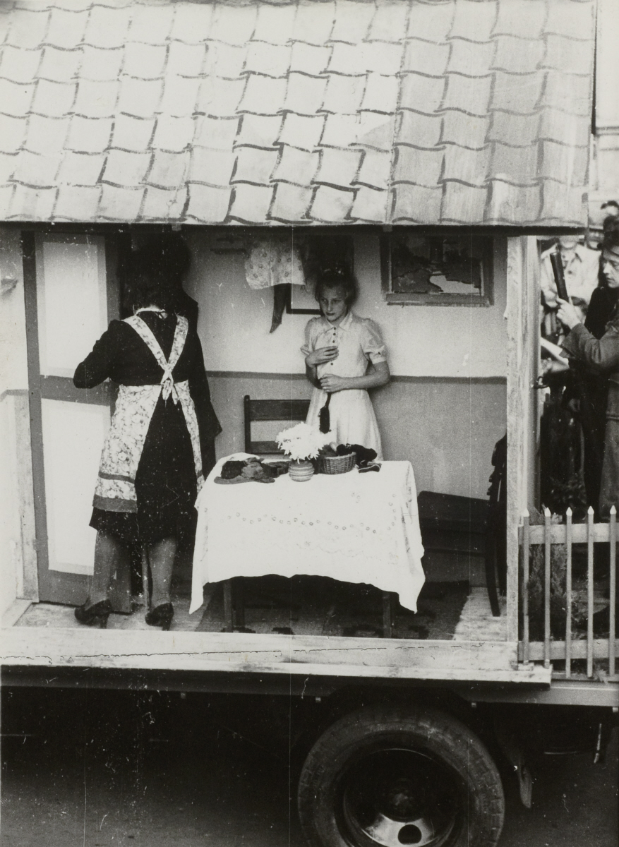 Een praalwagen met twee vrouwen in een wachtershuisje in een optocht