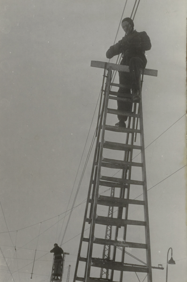 Twee mannen op ladders bij bovenleiding
